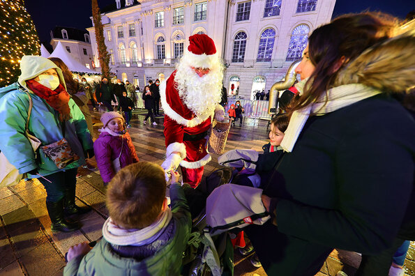 Le père Noël distribue des bonbons aux enfants sur la place du Martroi